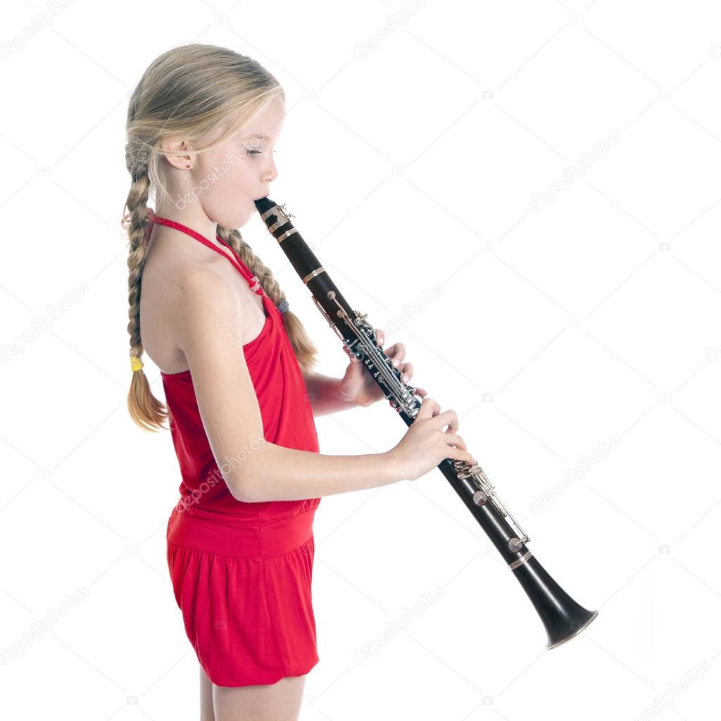 young blond girl in red playing clarinet