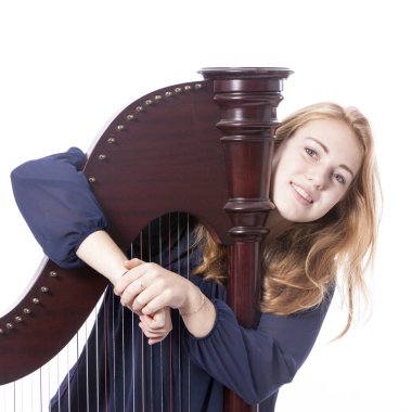 Kırmızı sarışın genç kız beyaz stüdyo backgr karşı harp kucaklayan