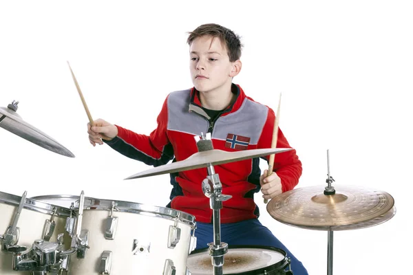 Tiener speelt drums in studio met witte achtergrond — Stockfoto