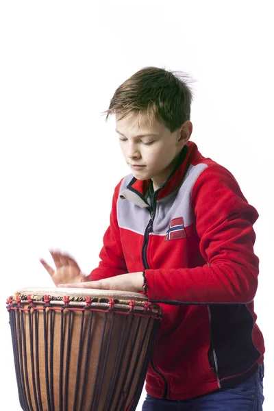 Teenager plays the djembe in studio with white background — Stock Photo, Image
