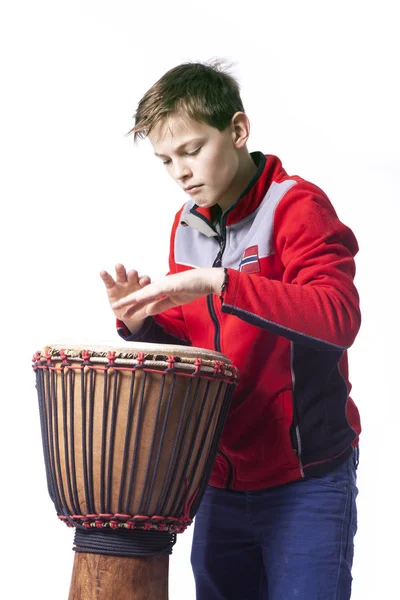 Tonåring spelar djembe i studio med vit bakgrund — Stockfoto