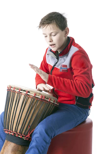 Tonåring spelar djembe i studio med vit bakgrund — Stockfoto