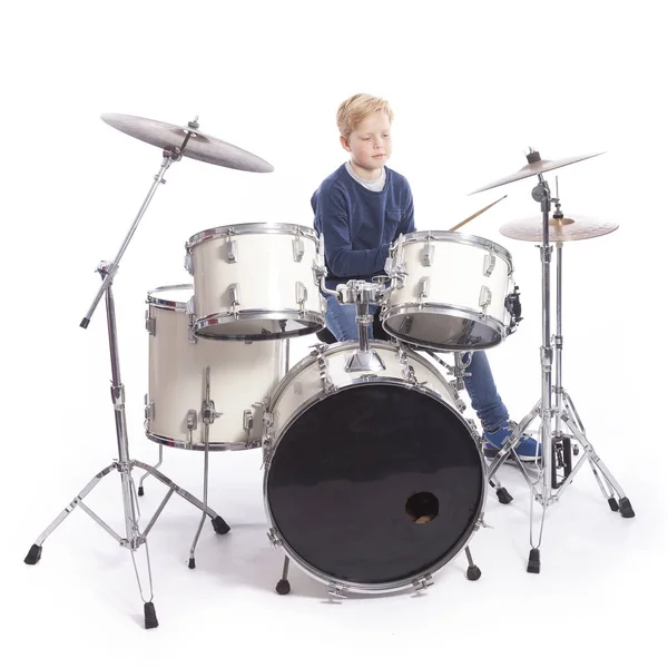 Young caucasian boy at drum kit in studio plays music — Stock Photo, Image