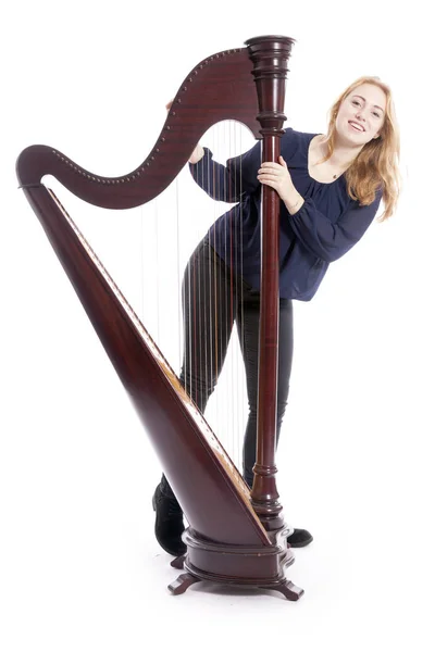 Vermelho loira adolescente fica com harpa contra branco estúdio bac — Fotografia de Stock