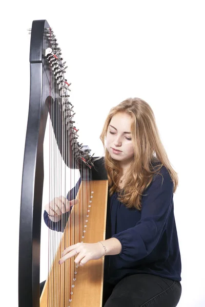 Red blond teenage girl with harp against white studio background — Stock Photo, Image