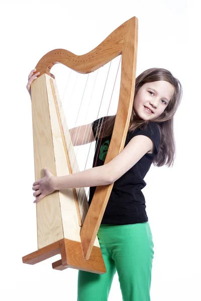 Young girl in black shirt carries harp in studio and smiles — Stock Photo, Image