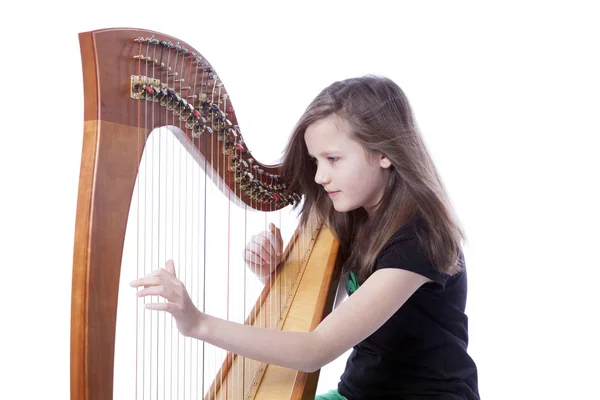 Fiatal lány zöld nadrágot hárfa játszik stúdió — Stock Fotó