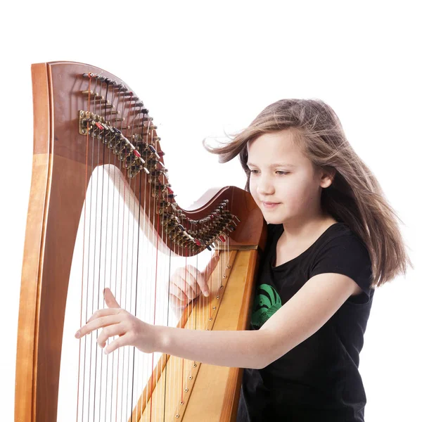 Jovem menina em camisa preta toca harpa no estúdio — Fotografia de Stock