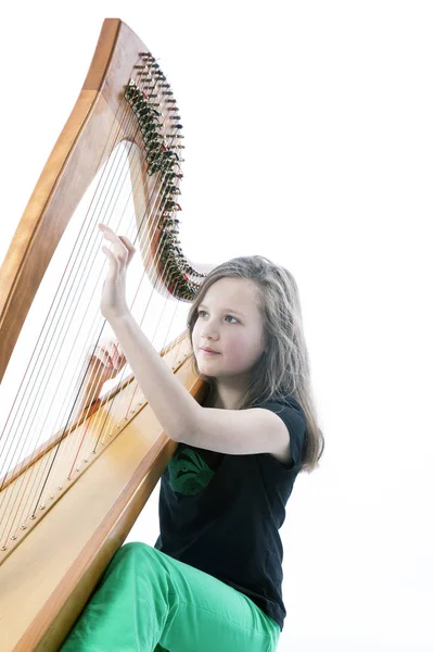 Jeune fille en pantalon vert joue de la harpe en studio — Photo