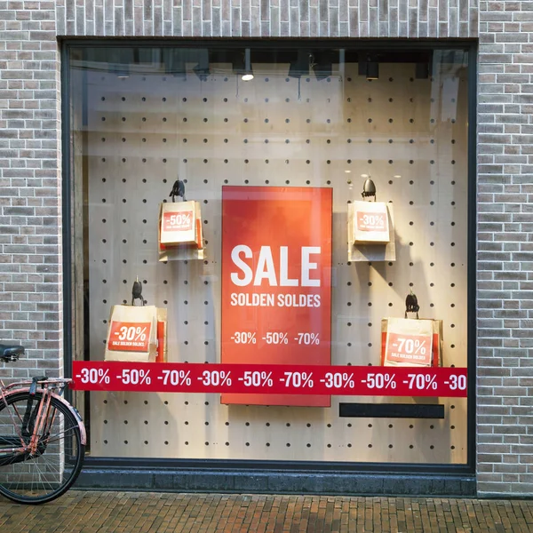 Πώληση υπογράφει στις τσάντες εγγράφου στο παράθυρο εμφάνισης της κατάστημα ενδυμάτων — Φωτογραφία Αρχείου