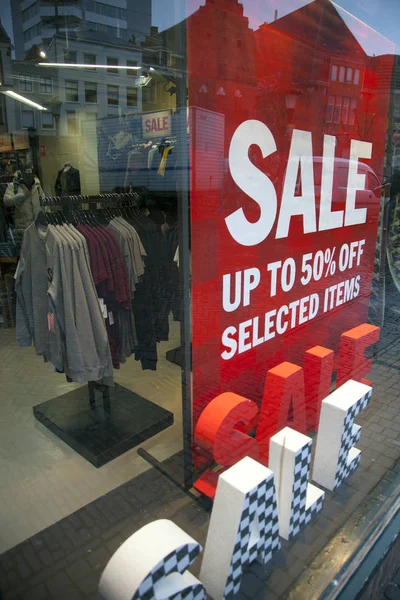 Sinais de venda na janela de exibição da loja de roupas — Fotografia de Stock