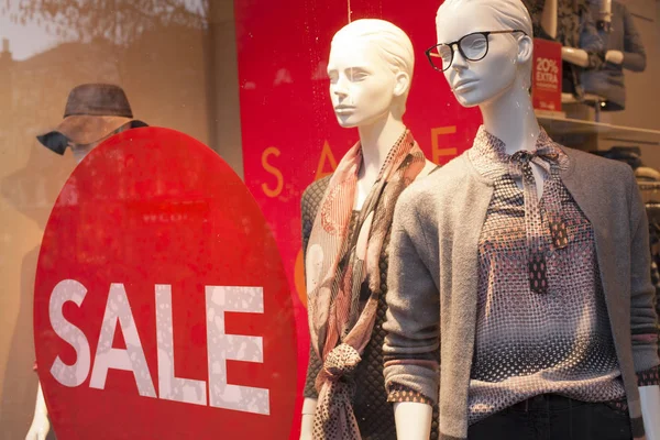 Sale sign on shop window and fashion dolls in the store — Stock Photo, Image