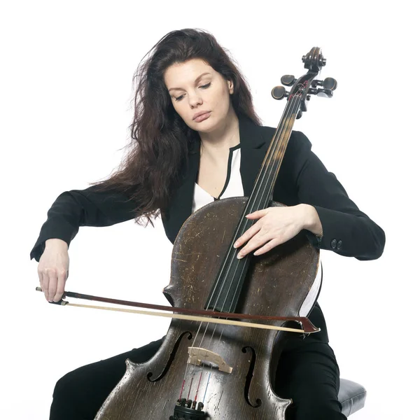 Bela morena mulher toca violoncelo no estúdio contra branco — Fotografia de Stock