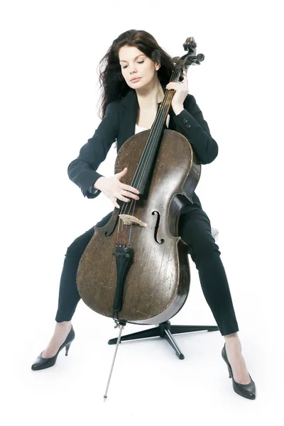 Bela morena mulher toca violoncelo no estúdio contra branco — Fotografia de Stock