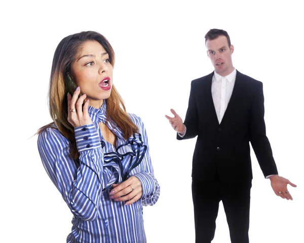 Young woman talks into mobile phone while boss looks from behind — Stock Photo, Image