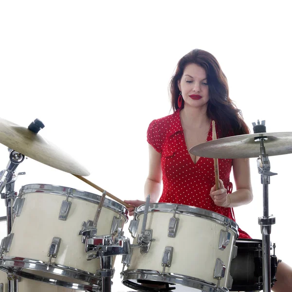 Sexy morena no vestido vermelho toca bateria kit no estúdio — Fotografia de Stock