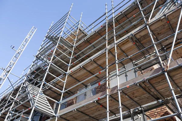 Andamios bajo el cielo azul en nuevas instalaciones de vivienda en la parte inferior —  Fotos de Stock