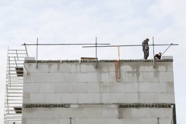 yapım aşamasında yeni binasının çatısında iki işçi