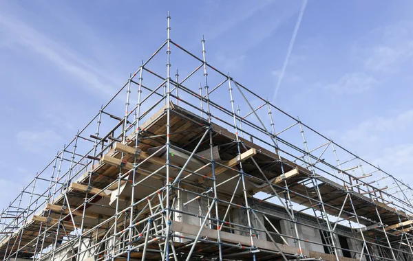 Scaffolding on building site of new apartment building and blue — Stock Photo, Image