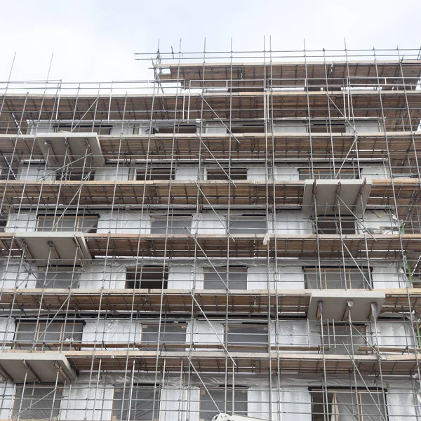Scaffolding on building site of new apartment building and sky — Stock Photo, Image