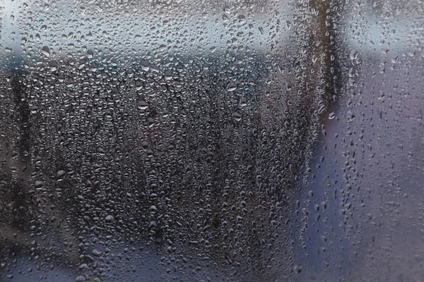 Raindrops on window of car and background in shades of blue — Stock Photo, Image