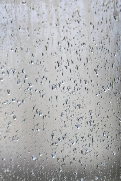 Стекло с каплями дождя и водой — стоковое фото