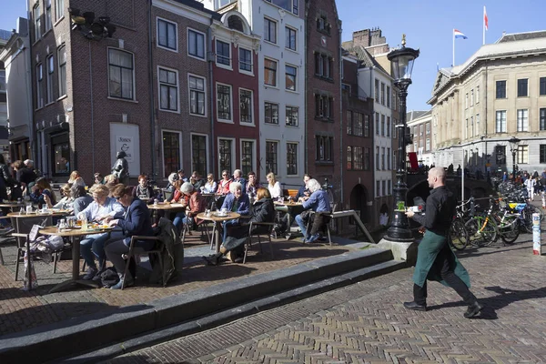 Mensen genieten van zonnige dag in het vroege voorjaar op openlucht café op visma — Stockfoto