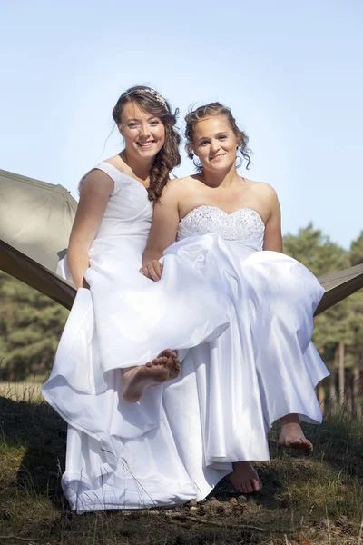 Két menyasszony fehér ruhák jelentenek a függőágy Simai erdőben — Stock Fotó