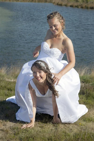 Щойно одружена щаслива лесбіянка пара в білій сукні розважається поблизу sm — стокове фото
