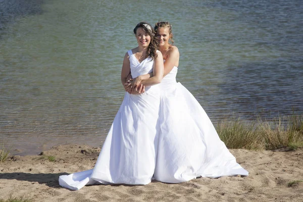 Acaba de casarse feliz lesbiana pareja en blanco vestido abrazo cerca sm — Foto de Stock