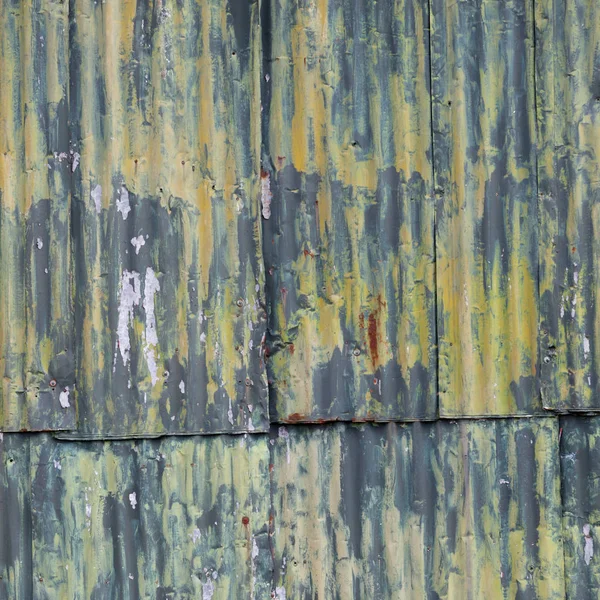 Rusty corrugated iron doors of shed with green yellow paint — Stock Photo, Image