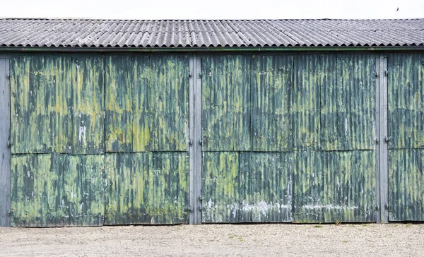 Puertas de hierro corrugado oxidado de cobertizo con pintura verde amarilla — Foto de Stock