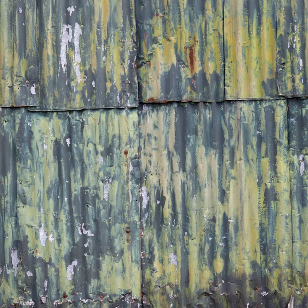 paslı oluklu demir duvar ile yeşil sarı boya dökmek