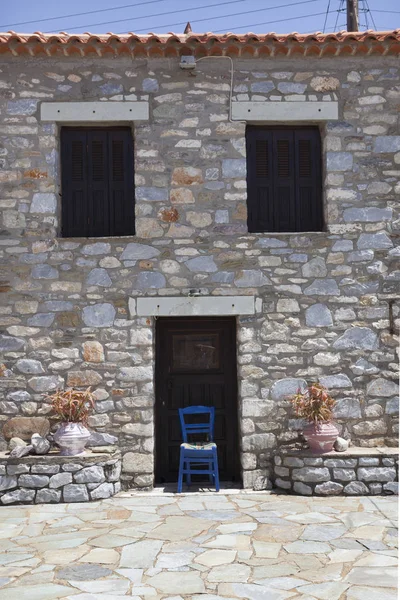 Silla azul frente a casa típica griega en agios dimitrios — Foto de Stock