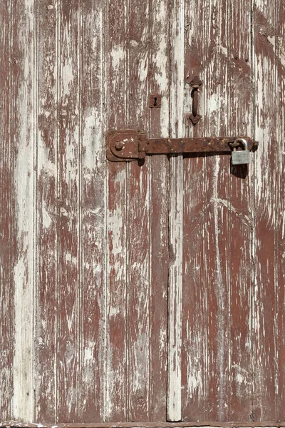 Gembok dan menangani pada grungy tua pintu coklat dengan cat mengupas — Stok Foto