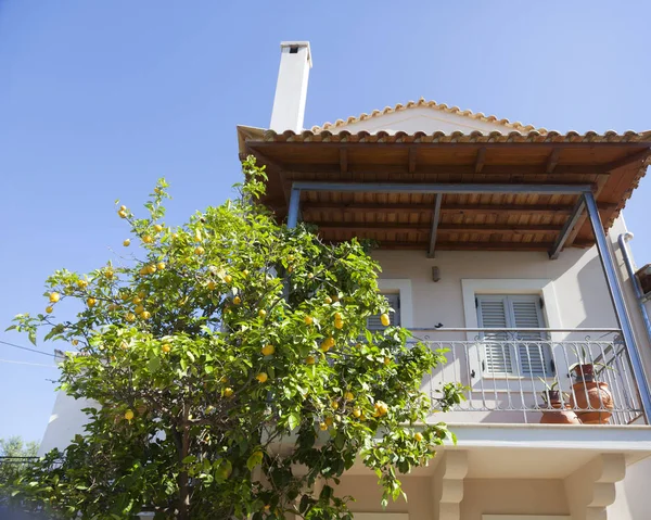 Limon ağacının yanında Yunan kasabasında balkon ve mavi gökyüzü ile ev — Stok fotoğraf