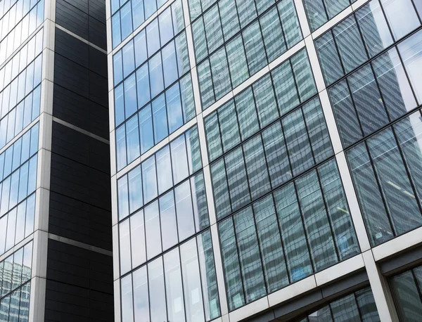 Edifícios altos modernos com reflexos do céu azul e clou — Fotografia de Stock