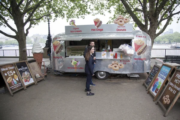 Jeune couple aime café et beignets au stand de hot dog sur tha — Photo