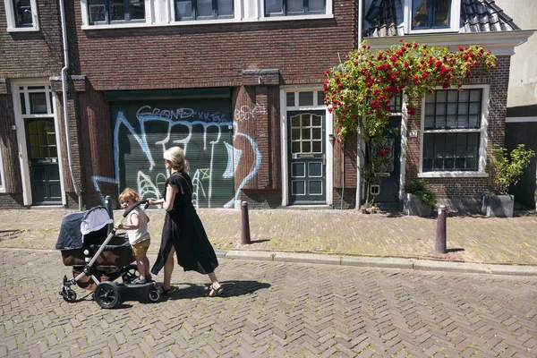 Moeder en kind meisje lopen de straat met vervoer in leeuwarde — Stockfoto