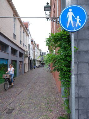 Kız bisiklet üzerinde eski dar sokaktan merkezinde sürmek. 