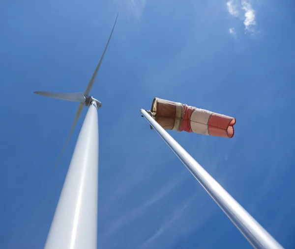 Sac à vent et éolienne contre ciel bleu — Photo