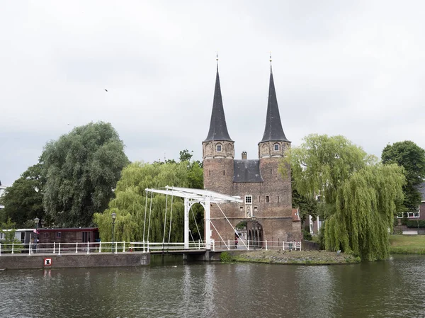 Femme et garçon à vélo près de oostpoort dans la vieille ville néerlandaise de del — Photo