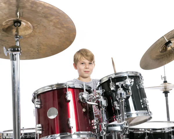 Mladý dospívající chlapec hraje na bicí ve studiu proti bílým poza — Stock fotografie