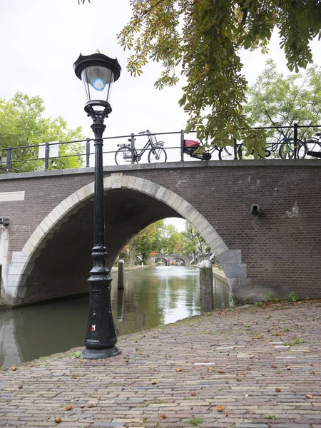 Pouliční lampy a most přes oude gracht v holandské město utrecht — Stock fotografie