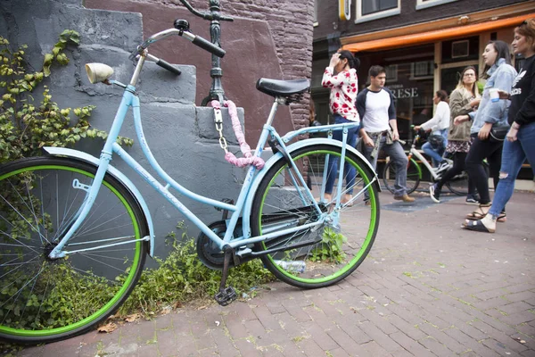 La gente pasa vieja bicicleta azul y verde en el centro de Amsterdam — Foto de Stock