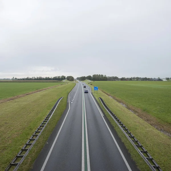 Основна дорога на північ від гранінгенського міста між зеленими луками на півночі Голландії — стокове фото