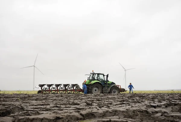 Tierra recién arada y tractor con arado —  Fotos de Stock