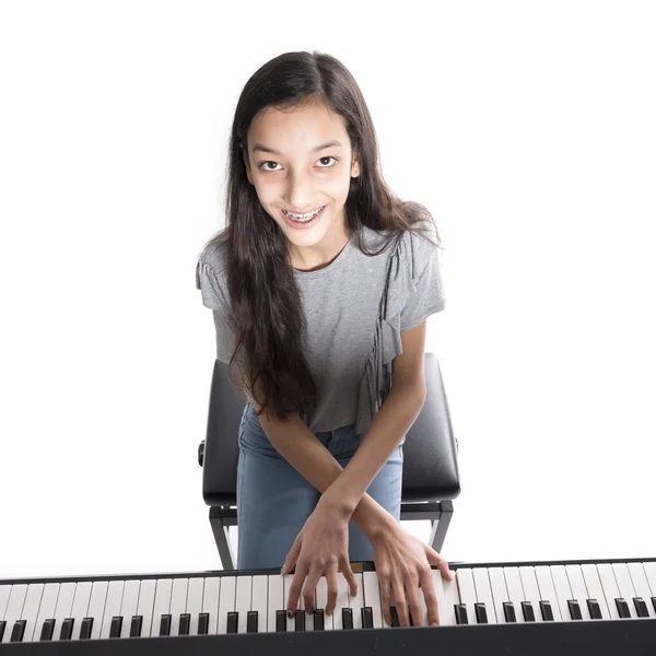 Teenage brunette girl and black upright piano in studio — Stock Photo, Image