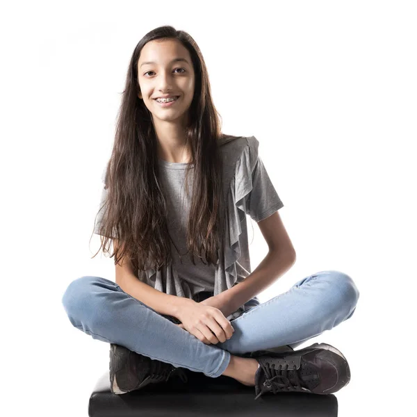 Dospívající brunetka na černé klavírní stolička ve studiu — Stock fotografie