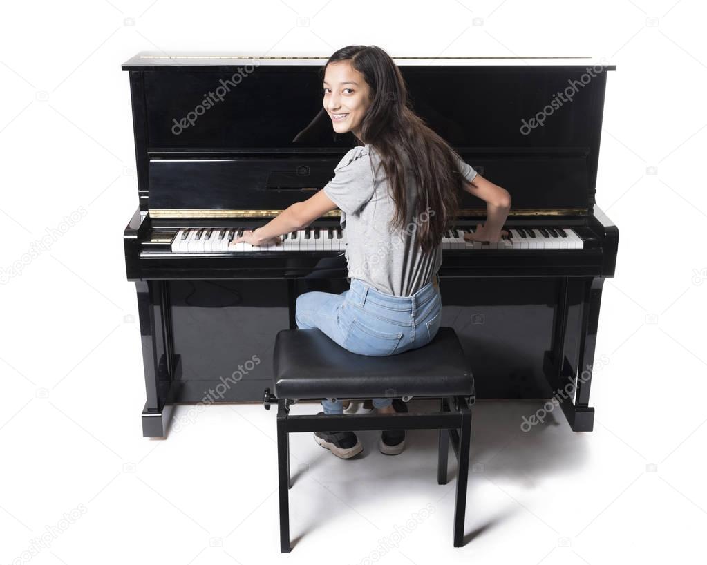 teenage brunette girl and black upright piano in studio